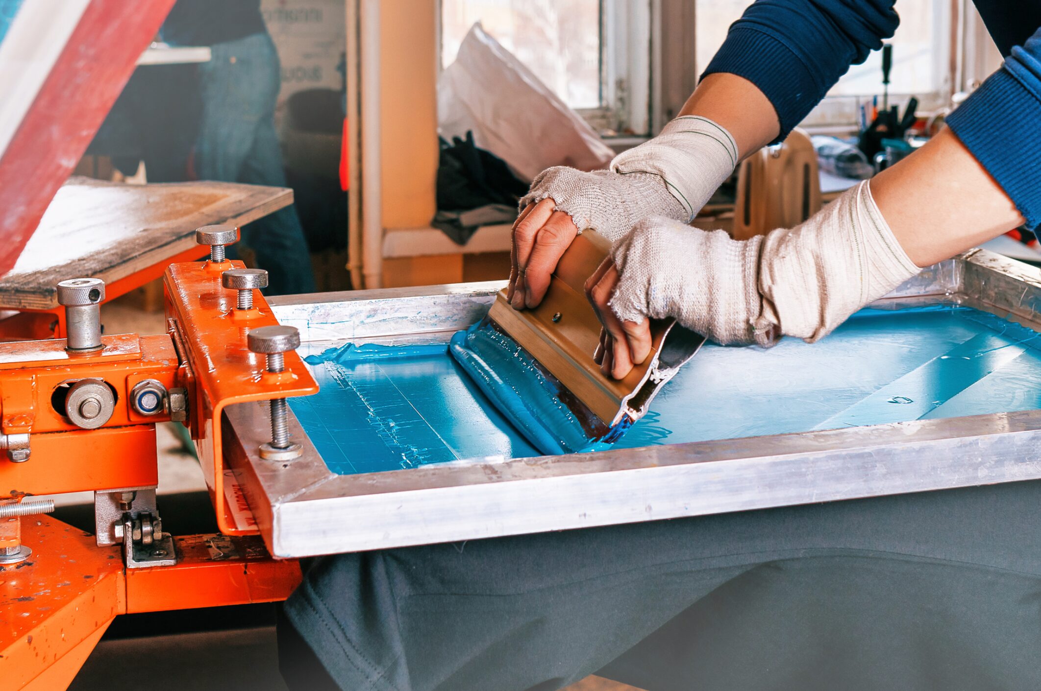 Person screen printing with blue ink.