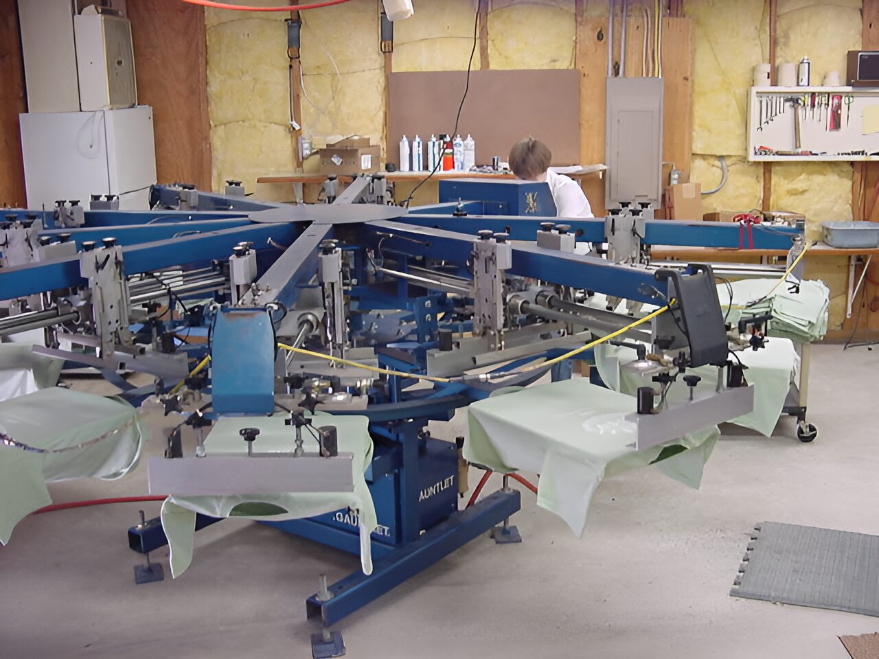 Screen printing machine in workshop setting.
