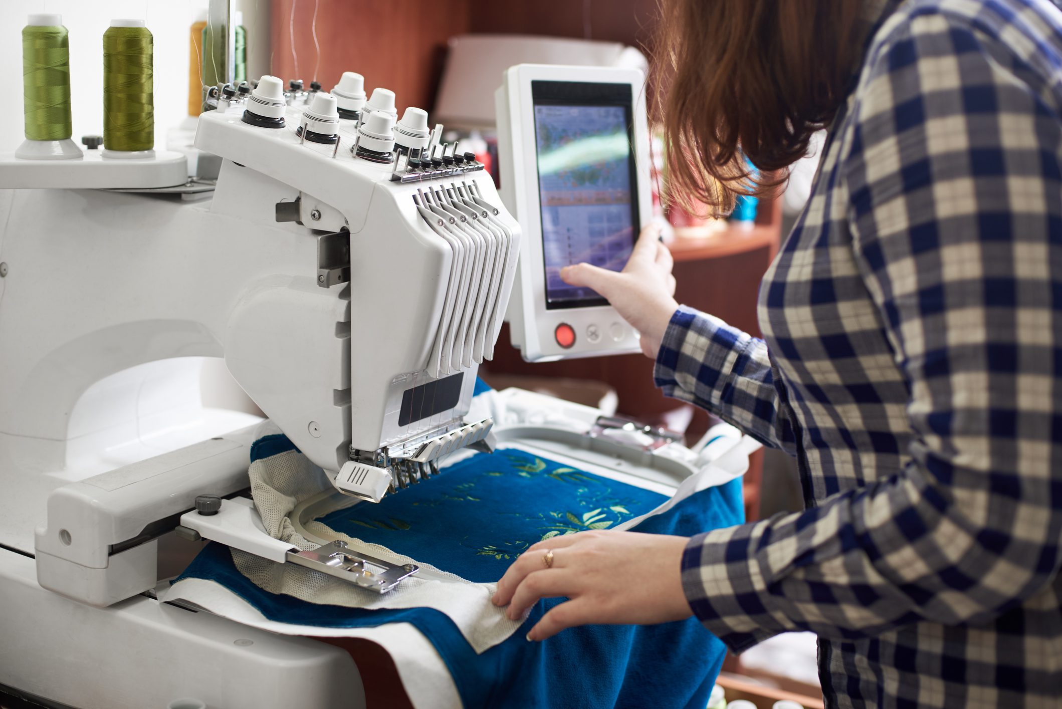 Person operating an embroidery machine.