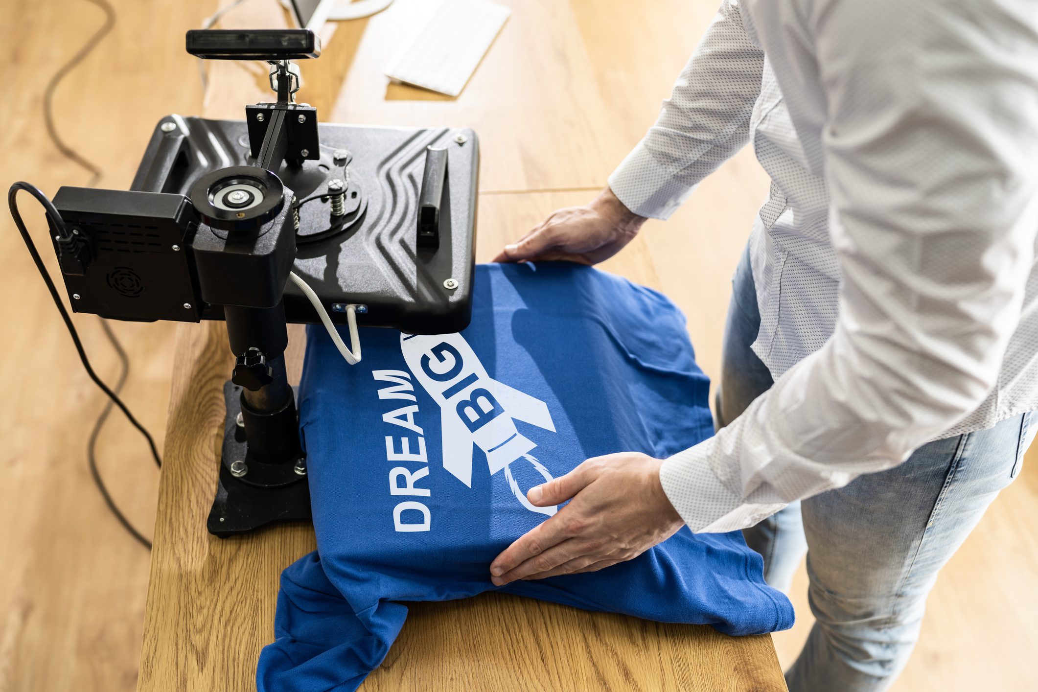 Person heat pressing "Dream Big" on shirt.