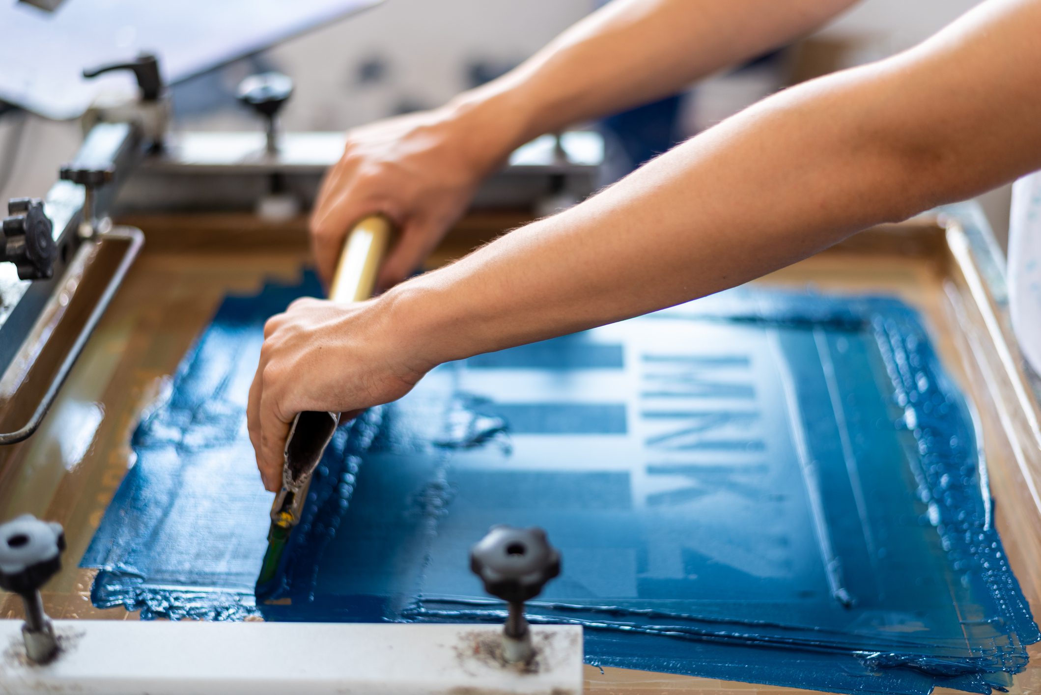 Person screen printing with blue ink.
