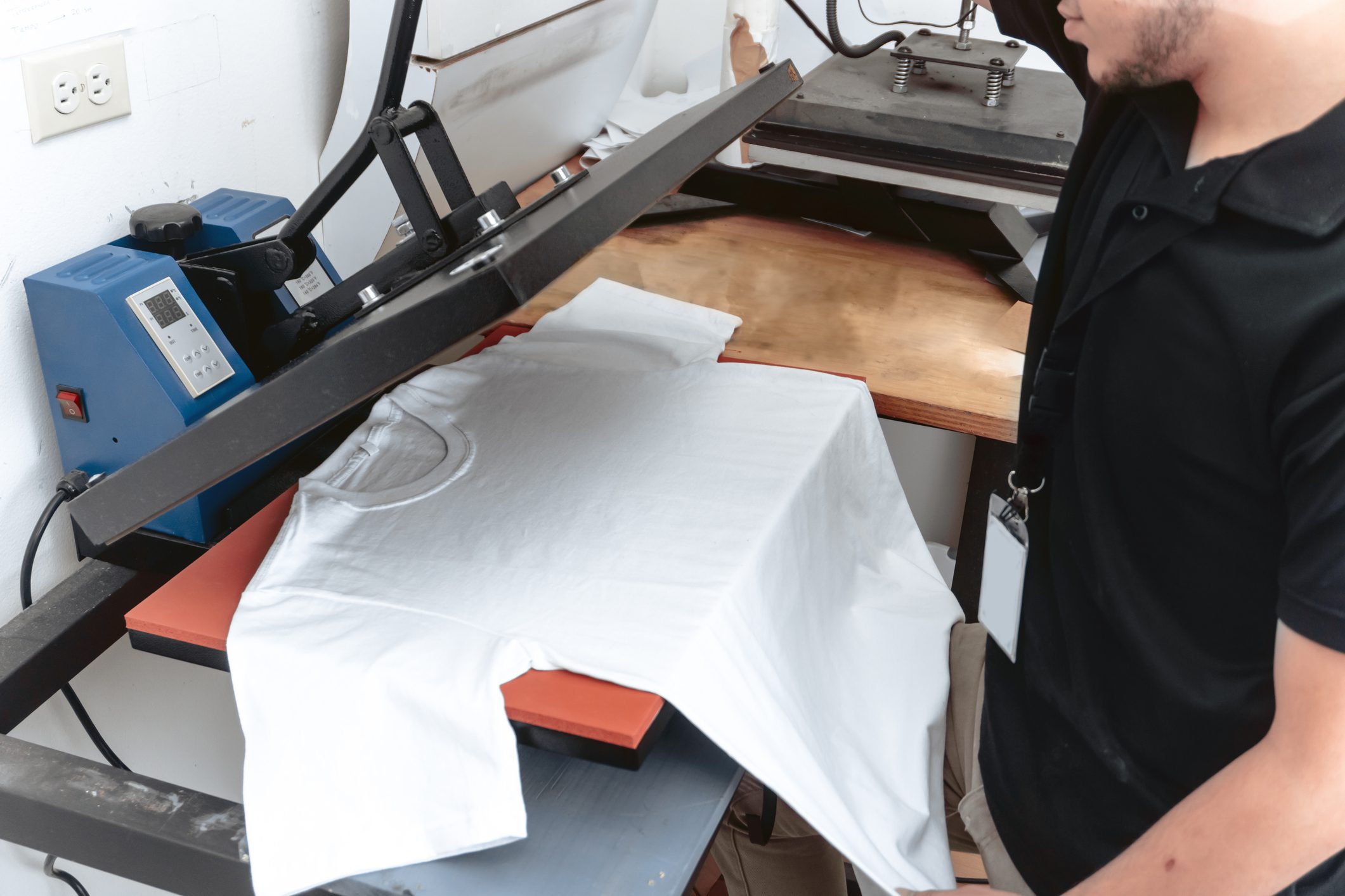 Person using a heat press on T-shirt.