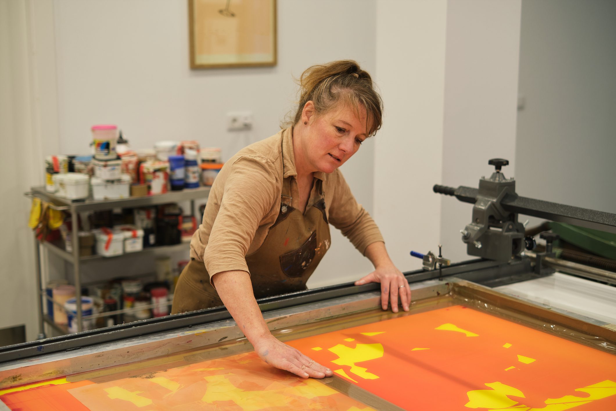Artist creating vibrant print in studio.
