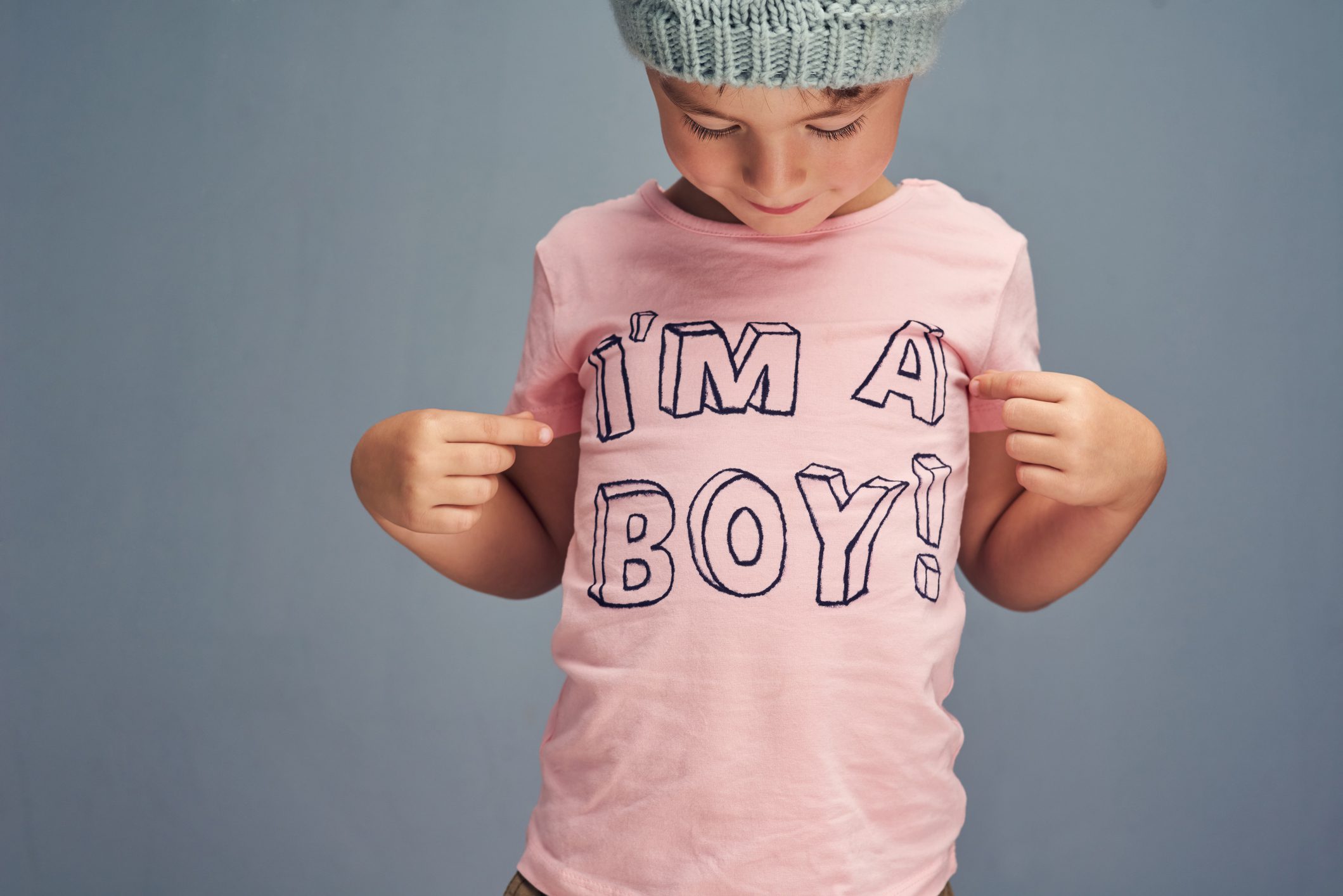 Child wearing "I'm a boy" pink shirt.