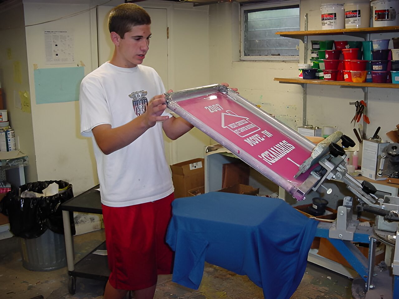 e676522fd1c271e4b8efca00260a26a3-Picsart-AiImageEnhancer Person screen printing on a blue shirt.