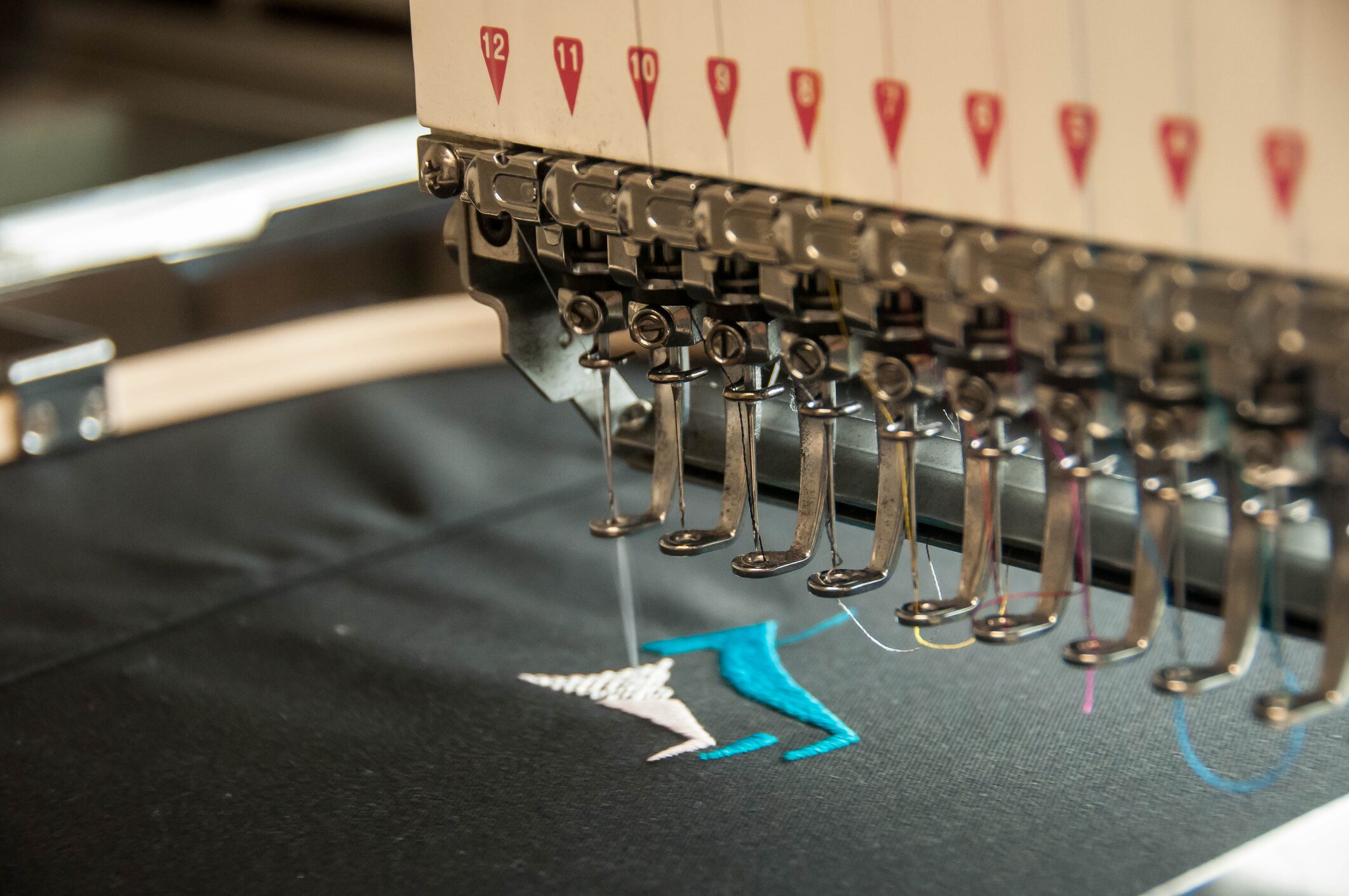 Embroidery machine stitching colorful fabric design.